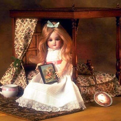 A doll sitting on top of a wooden chair.