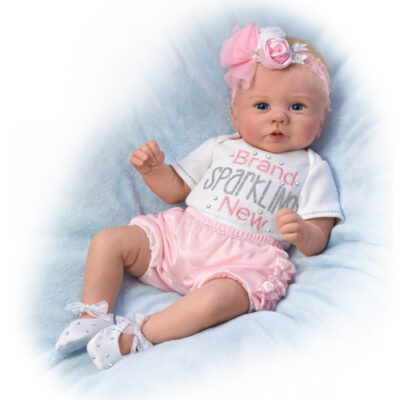 A baby doll wearing pink and white clothes.