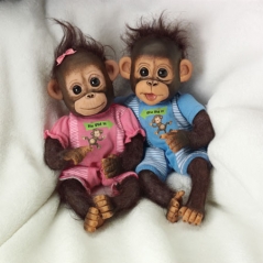 Two monkeys are sitting on a blanket and one monkey is wearing pajamas.