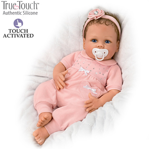 A baby doll with pink clothes and a headband.