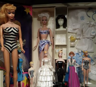 A group of barbie dolls in different outfits.