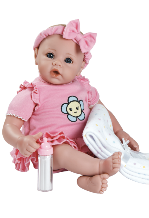 A baby doll is sitting on the floor
