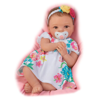 A baby girl is wearing a dress and holding her pacifier.