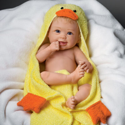 A baby is wrapped in a yellow duck towel.