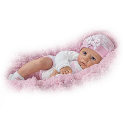 A baby doll wearing pink clothes and hat.