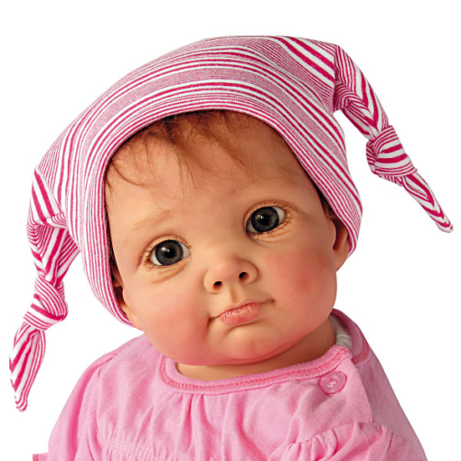A baby girl wearing pink and white striped hat.